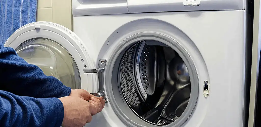 Washing machine repair handyman checking a front-load washer door and latch in Overland Park, KS