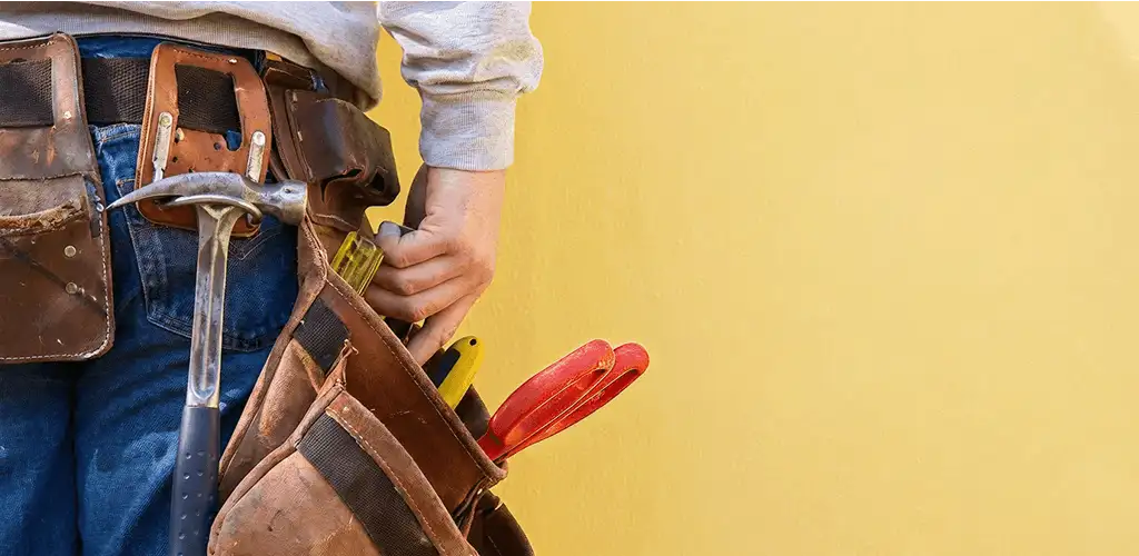 Handyman with tool belt ready for home repairs and maintenance in Overland Park, KS