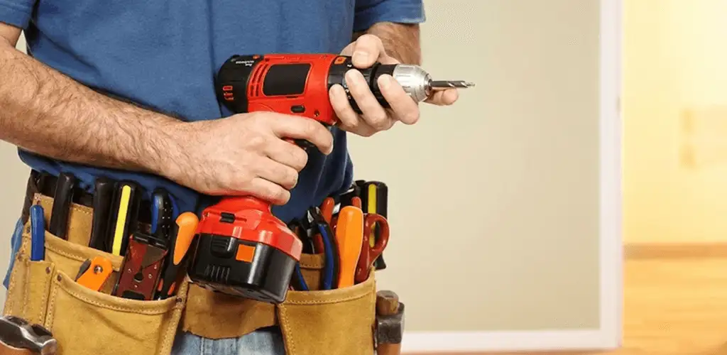 Handyman holding a power drill for home repairs and installations in Overland Park, KS