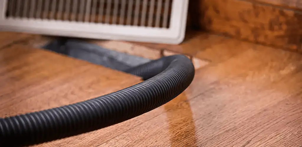 Air duct cleaning hose inserted into a floor vent for ductwork cleaning in Overland Park, KS