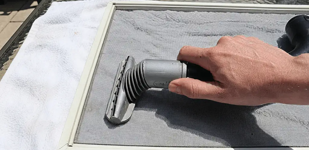 Window screen repair cleaning and fixing a damaged screen mesh in Overland Park, KS